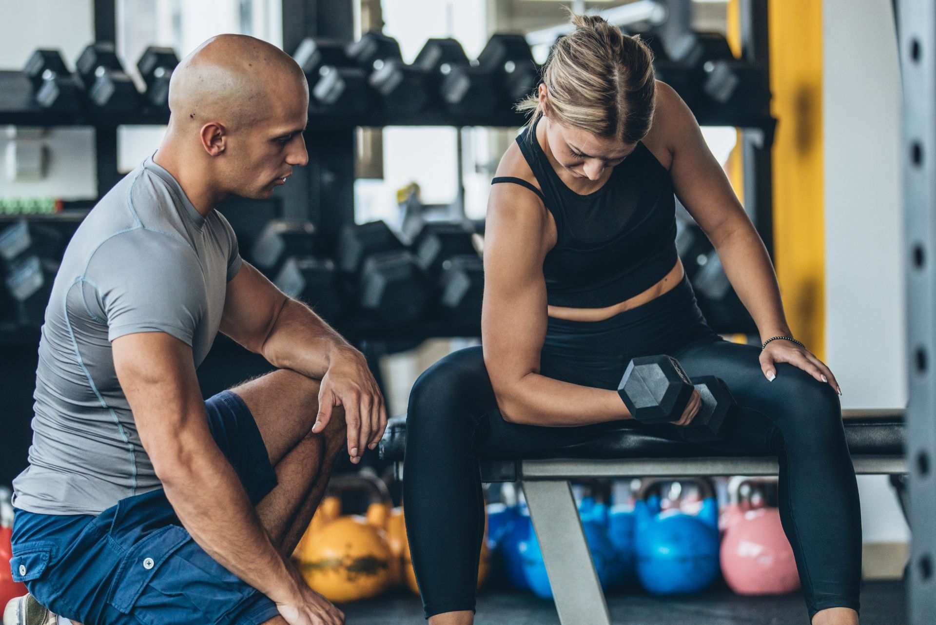 fitness trainers training woman at the gym